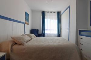 ein Schlafzimmer mit einem Bett, einer Kommode und einem Fenster in der Unterkunft AranPe PLAYA CÁDIZ in Cádiz