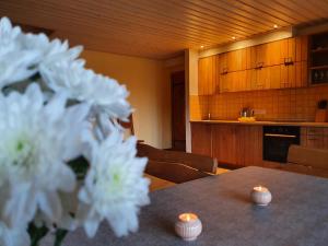 a kitchen with a table with candles and white flowers at Sodyba PILIAKIEMIS in Kurkliškės