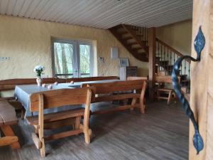 a room with a table and benches and a staircase at Sodyba PILIAKIEMIS in Kurkliškės
