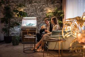 um homem e uma mulher sentados numa cadeira numa sala de estar em Fernblick em St. Corona am Wechsel