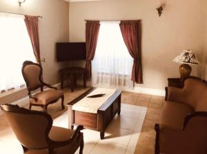 a living room with a couch and a table and chairs at Summer Grove Villa in Kololi