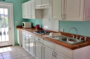 a kitchen with a sink and a stove top oven at Summer Grove Villa in Kololi