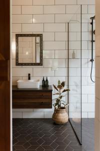 a bathroom with a sink and a mirror at The Villa at Bali Garden Matakana in Omaha