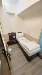 Cette petite chambre comprend un lit. dans l'établissement SAAN INN, à Hong Kong