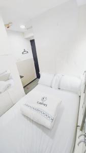 Cette chambre blanche comprend 2 lits. dans l'établissement SAAN INN, à Hong Kong