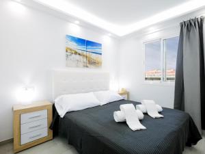 a bedroom with a bed with two white towels at 5B Jardines Canarios sul Mar Smart Tv y Fibra in Los Cristianos +19 photos