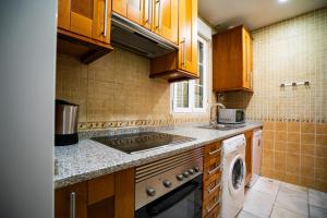 a kitchen with wooden cabinets and a washer and dryer at Smartr Madrid La Latina in Madrid