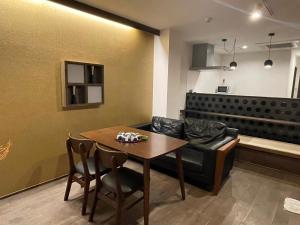 a living room with a table and a couch at Guesthouse Raku in Kyoto