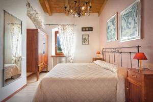 Un dormitorio con una cama grande y una lámpara de araña. en Casale Faigolo-Vista lago, en Navene