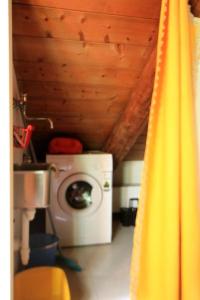 bagno con lavatrice e tenda gialla di Il Villino Rosa a San Paolo Solbrito