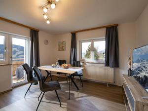 a dining room with a table and chairs and windows at Haus Gletscherblick in Westendorf +14 photos