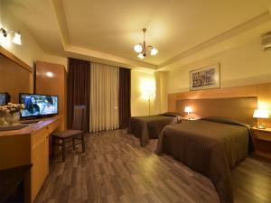 Habitación de hotel con 2 camas y TV de pantalla plana. en Hotel Doro City, en Tirana