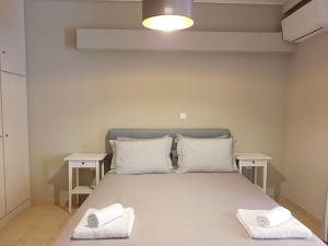 a bed with two white towels on top of it at Athens Campus Renovated Studio Apartment @ Ilisia in Athens
