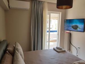 a bedroom with a bed and a tv on the wall at Athens Campus Renovated Studio Apartment @ Ilisia in Athens