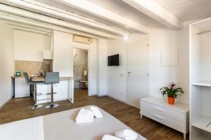 biała sypialnia z łóżkiem i biurkiem w obiekcie Trisina Rooms w mieście Avola