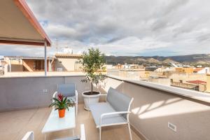 balkon z 2 krzesłami, stołem i rośliną w obiekcie Trisina Rooms w mieście Avola