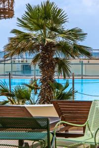 a palm tree and chairs next to a pool at Cotillo Ocean Waves 1 in Cotillo