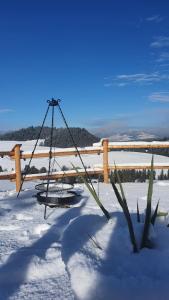 un'altalena nella neve vicino a una recinzione di Górskie Tarasy a Dursztyn