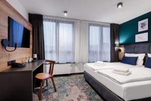 スタルガルトにあるKyriad Stargardのベッド2台とデスクが備わるホテルルームです。