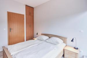um quarto com uma cama branca e 2 almofadas em Apartamenty Świnoujście - Zacisze Leśne em Świnoujście