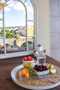una bandeja de fruta en una mesa frente a una ventana en a casa da Alicia, en Monforte de Lemos