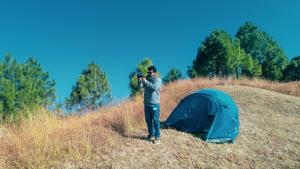 Kandāghāt的住宿－Secret Staycation Nature Cottages，一名男子在帐篷旁边拍张照片