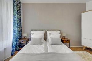 1 dormitorio con 1 cama con sábanas y almohadas blancas en Downtown Apartments Śląska 12 en Gdansk