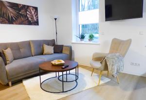 sala de estar con sofá y mesa en Modernes Apartment mit Queensize-Bett, NETFLIX, Küche, Erdgeschoss, Nähe AMEOS Klinik, en Aschersleben