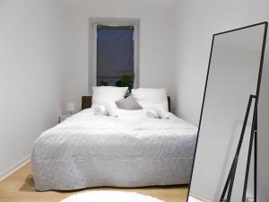1 dormitorio con cama blanca y espejo en Modernes Apartment mit Queensize-Bett, NETFLIX, Küche, Erdgeschoss, Nähe AMEOS Klinik, en Aschersleben