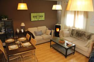 a living room with a couch and a table at Apartamentos Alcazar de Baeza in Baeza