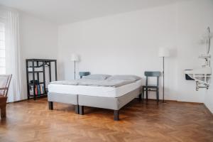 Cama blanca en habitación con suelo de madera en Zweitwohnsitz en Drosendorf Stadt