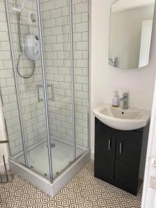 锡福德Spacious Studio Cabin with Sea/ Downs views Sole Use of HotTub in Seaford的带淋浴和水槽的浴室