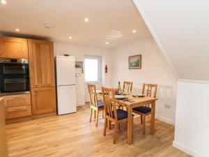 uma cozinha e sala de jantar com mesa e cadeiras em Stable Cottage em Brampton