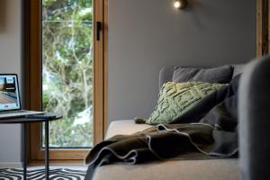 una manta sentada en un sofá junto a una ventana en Aparthotel Chalina en Leutasch