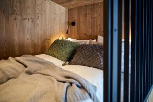 a bed in a room with a wooden wall at Aparthotel Chalina by Peak Stay in Leutasch
