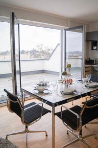 uma sala de jantar com mesa e cadeiras e uma grande janela em Prime Park Family Deluxe Apartment Aschaffenburg em Aschaffenburg
