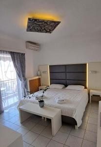 1 dormitorio con 1 cama grande y 1 mesa en Bicorna - Chania, en Plaka