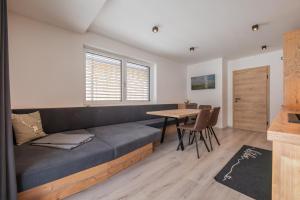 uma sala de estar com um sofá e uma mesa em Mountainlights Apartment em Neustift im Stubaital