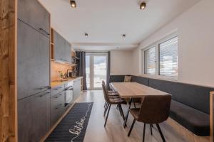 cocina con mesa y sillas en una habitación en Mountainlights Apartment en Neustift im Stubaital