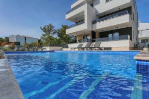 a villa with a swimming pool in front of a building at Villa Ankora 2 with heated pool in Biograd na Moru