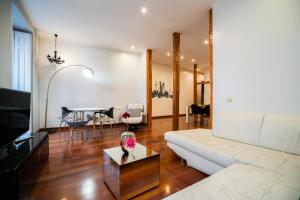 ein Wohnzimmer mit einem weißen Sofa und einem Tisch in der Unterkunft Smartr Madrid Atocha in Madrid