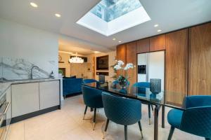 a dining room with a glass table and blue chairs at Westcourt by RMG Apartments in Harrogate