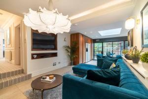a living room with a blue couch and a chandelier at Westcourt by RMG Apartments in Harrogate
