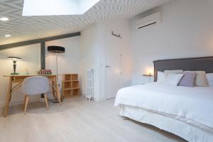 Habitación blanca con cama y escritorio en Dúplex Paseo de la Habana - Collection I, en Madrid