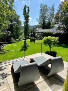 2 weiße Stühle auf einer Terrasse mit Garten in der Unterkunft Le Loft ATELIER in Fauvillers