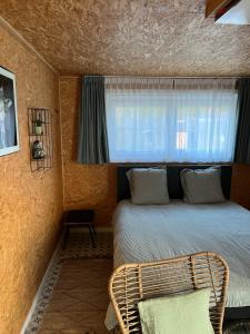sypialnia z łóżkiem i oknem w obiekcie Studio 't Hoveke w mieście Gullegem