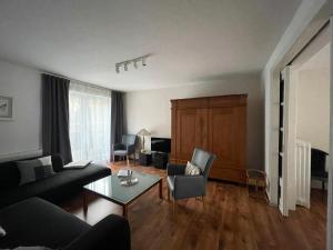 ein Wohnzimmer mit einem Sofa und einem Tisch in der Unterkunft Ruhige Doppelhaushälfte mit 5 Schlafzimmern im Villenviertel in Hamburg