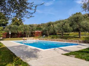a swimming pool in a yard with trees at Riviera degli Ulivi - Terrace over the castle in Torri del Benaco