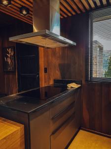 a kitchen with a stove top oven next to a window at LUTS Chalés in Gonçalves