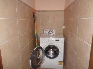 a washing machine in a corner of a bathroom at Home Relax Varna in Varna City